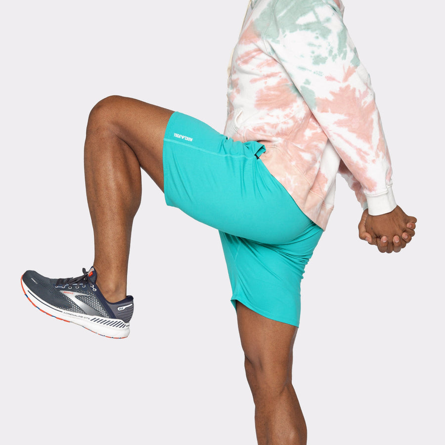 Model showcasing Swerve Men's Lined Yoga Shorts 7 Inch in Aqua Blue during exercise.