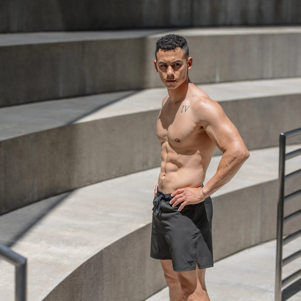 Man showing off Flow Men's Lined Hot Yoga Shorts 5 Inch in Faded Black, highlighting performance and style.