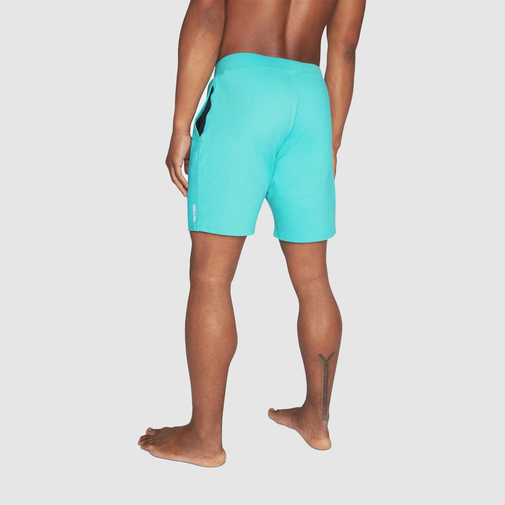 Back view of a man wearing Swerve Men's Lined Yoga Shorts 7 Inch in Aqua Blue color.