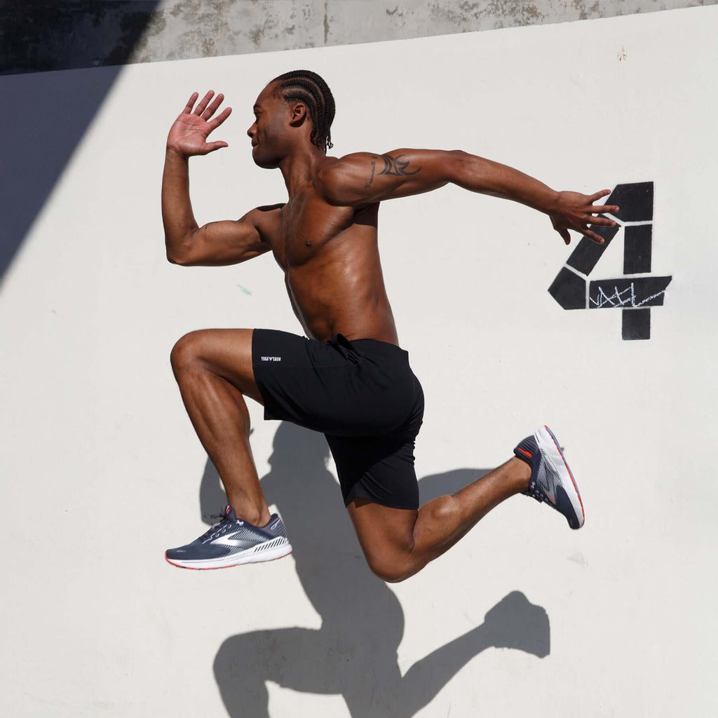 Man demonstrating agility in 4-way stretch Swerve Shorts - Crow Black during a workout.