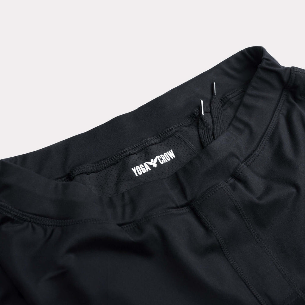 Close-up of 4-way stretch Swerve Shorts waistband in Crow Black color showcasing the Yoga Crow logo.