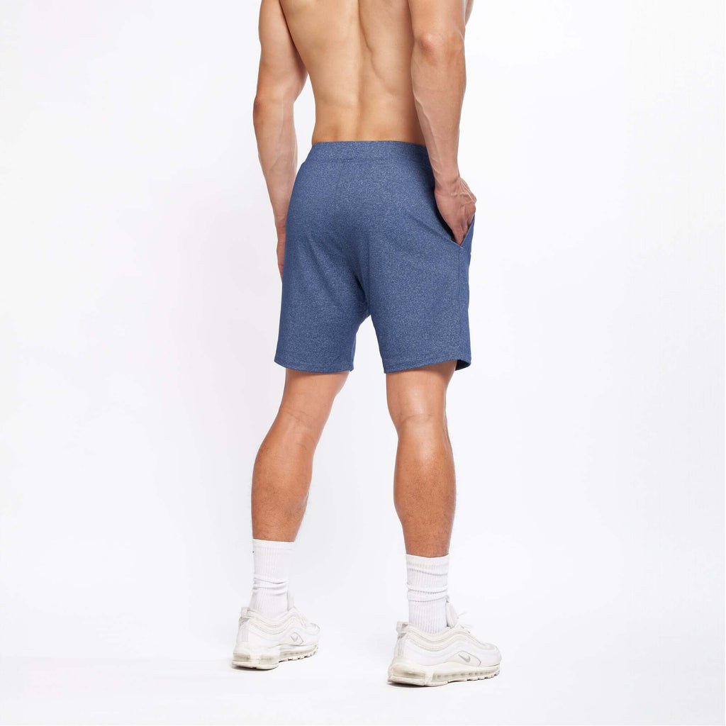 Back view of a man wearing 4-way stretch Swerve Shorts in Heather Navy, showcasing comfort and fit.