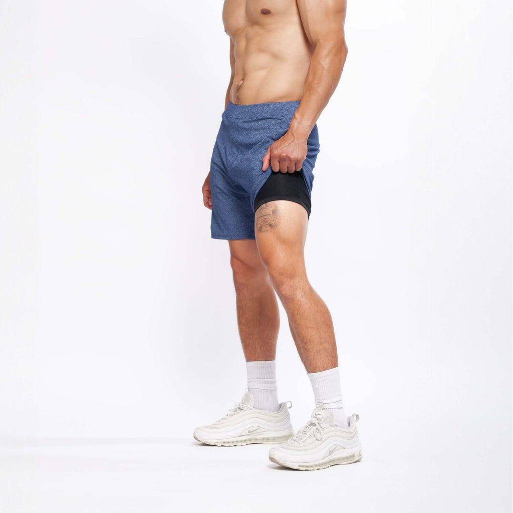 Model wearing 4-way stretch Swerve Shorts in Heather Navy, showcasing comfort and flexibility for active movement.